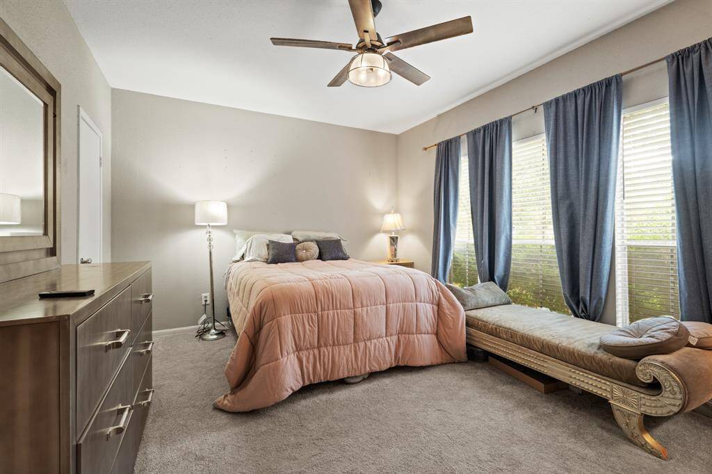 The primary bedroom offers a spacious and serene retreat, with soft lighting and a remote-controlled ceiling fan enhancing both comfort and ambiance. Large windows allow natural light to fill the space, making this the perfect haven for unwinding and relaxation.