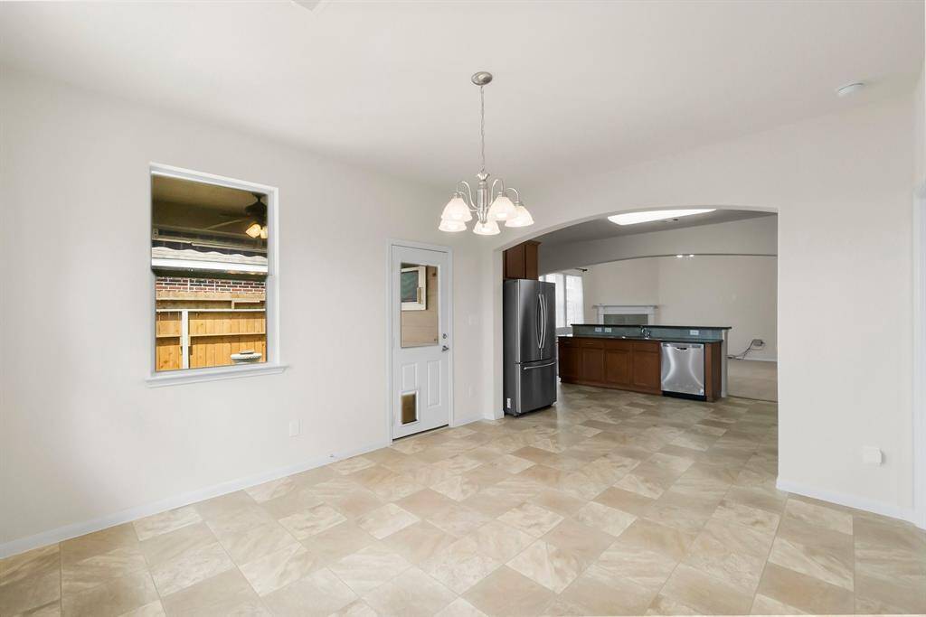 This photo shows a bright, functional laundry room with a washer and dryer, two wall shelves, a hanging rod, and a window for natural light.