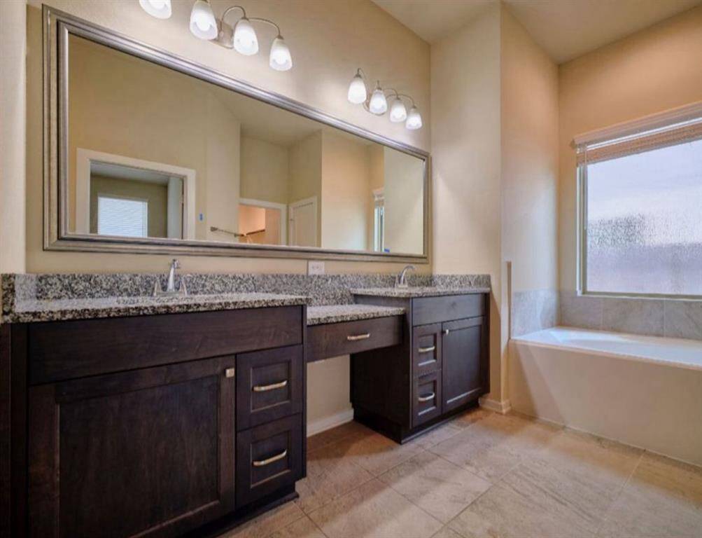 Elegant bathroom featuring J-Kraft cabinetry, granite countertops, cultured marble vanities, and matching bowl sinks. Enjoy sleek tile flooring and stylish Delta chrome faucets.