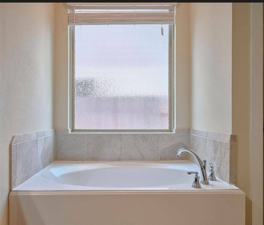 Luxurious oversized tub for ultimate relaxation. Garden tub with tile backsplash