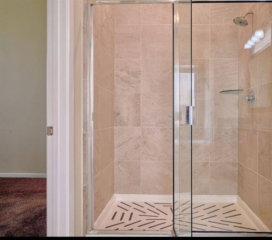 Modern walk-in shower with elegant tile design. Separate shower with tile surround