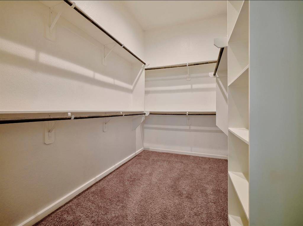 Discover the luxury of an expansive, air-conditioned walk-in closet with modern LED lighting.
