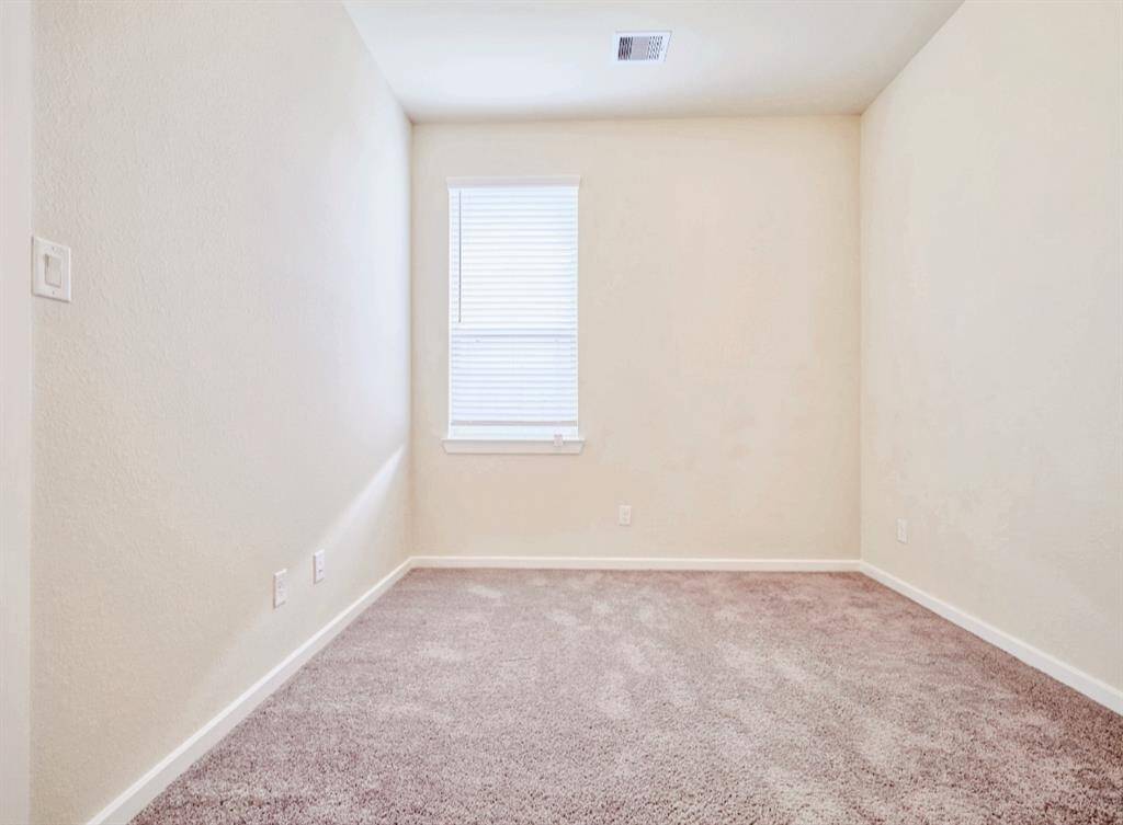 Cozy and bright, this bedroom offers soft carpet flooring and a large window for natural light. Perfect for relaxation or a home office.