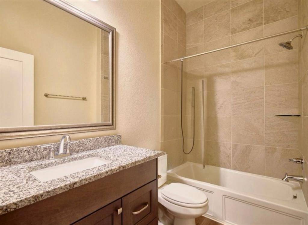 This full bathroom, located between bedrooms three and four, features a sleek cultured marble vanity with integrated sinks.