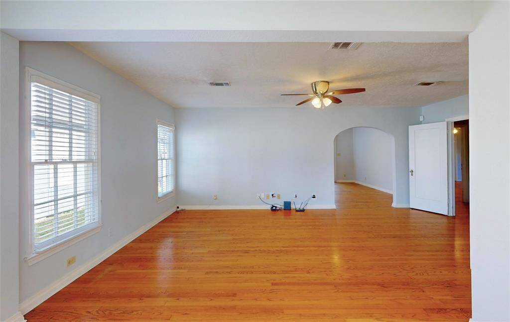 A view of the living room area with the arched entry access to the kitchen area on left of this picture, and entrance to the bedrooms hallways and bedrooms from the door to the right of the above picture.  Please note the 3-D interactive tour and the floor plan on this listing.