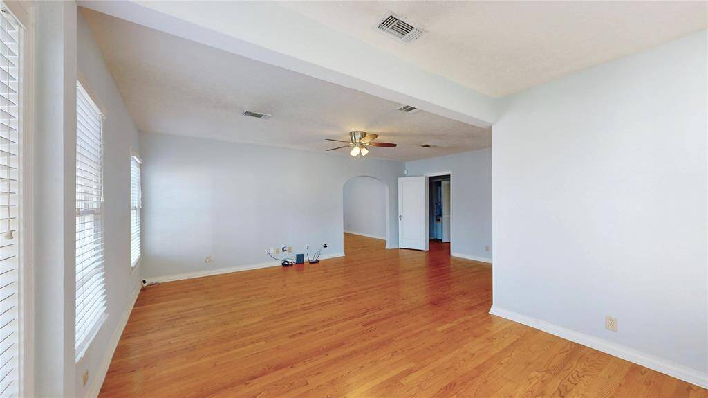 A view of the living room area with the arched entry access to the kitchen area on left of this picture, and entrance to the bedrooms hallways and bedrooms from the door to the right of the above picture.  Please note the 3-D interactive tour and the floor plan on this listing.