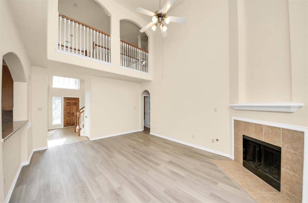 High ceiling living room with fireplace and new luxury vinyl flooring