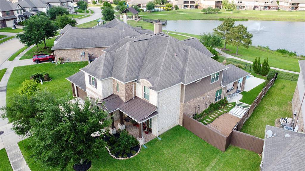 This spacious two-story brick home features a well-maintained yard, a covered porch, and a private fenced backyard with a patio. Located in a scenic neighborhood, it offers a beautiful view of a nearby pond with a fountain and walking paths.