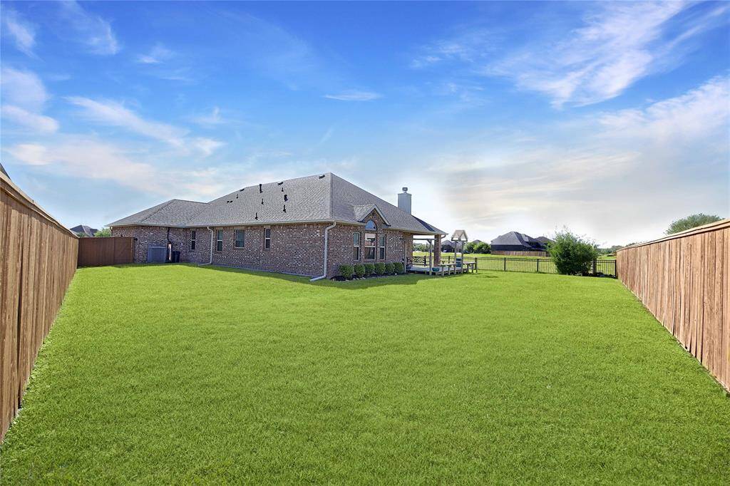 A sprawling, privacy-fenced backyard stretches out from the home, highlighted by a covered porch that’s ready for grilling, morning coffee, or evening get-togethers—plenty of space left over for pets, playsets, or a future garden.