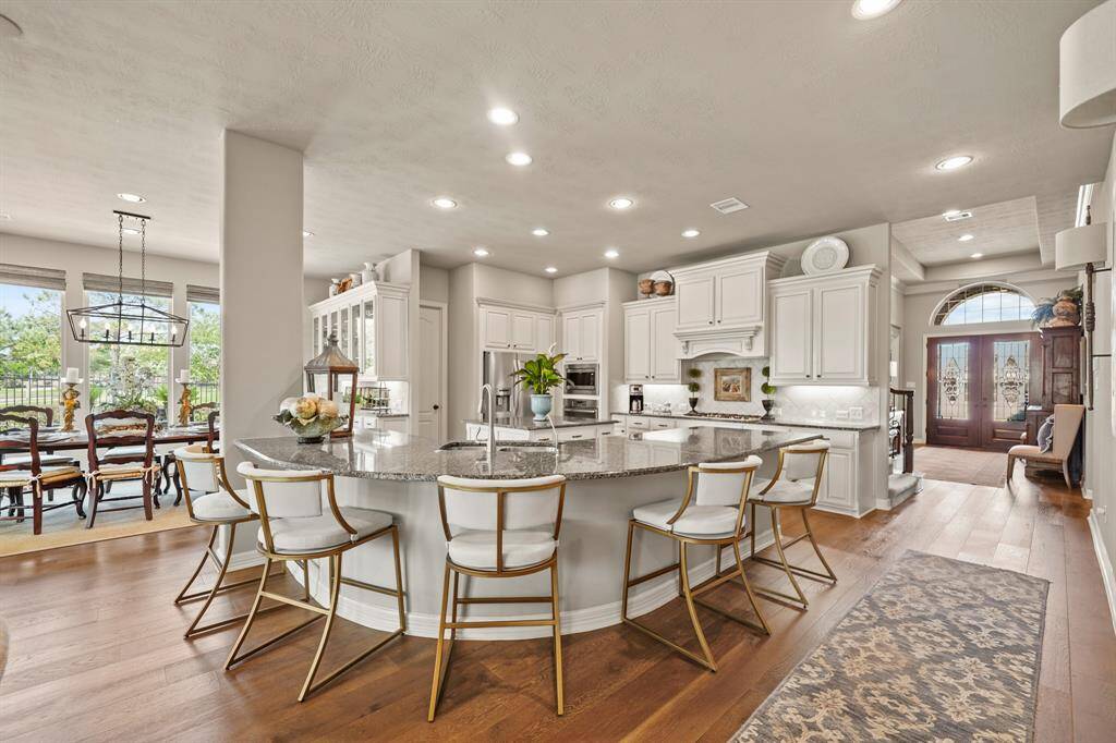 Upgraded cabinetry, granite counters and upgraded wood flooring beautifully accent this functional kitchen.  A 5 burner gas cooktop and dual stainless steel ovens offer convenience for the family chef.