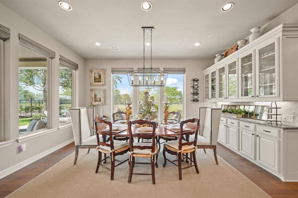 Just off of the kitchen, the dining area boasts lake views and beautiful and functional built-in serving bar and cabinetry.  Upgraded with custom remote control shades.