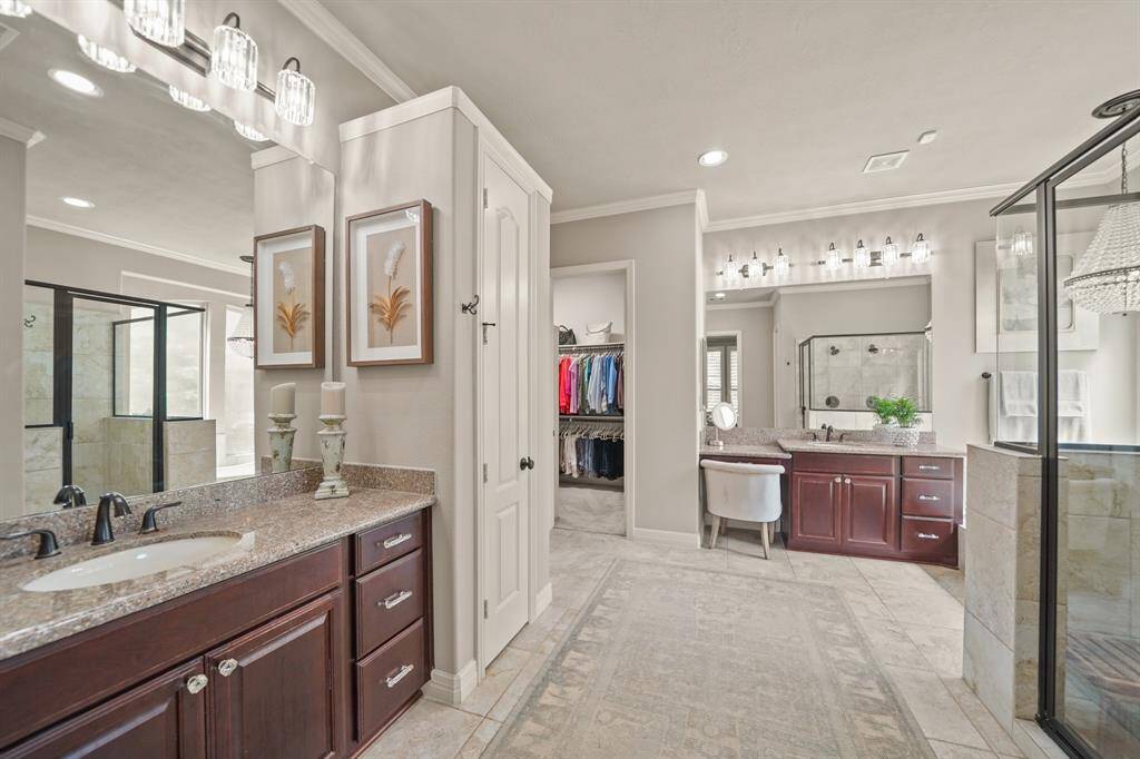 This bath boasts dual walk-in closets and a separate linen closet for ample storage.