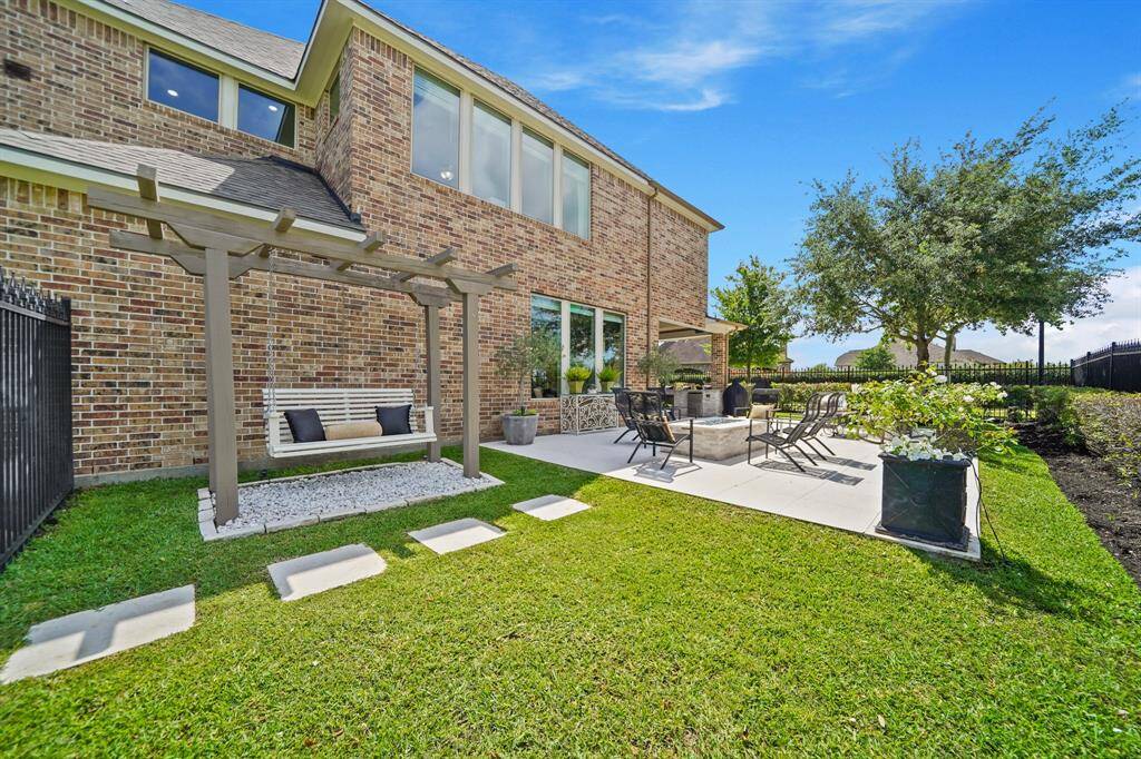 Travertine tile flooring and the pergola style swing add to the beautiful space overlooking the lake.