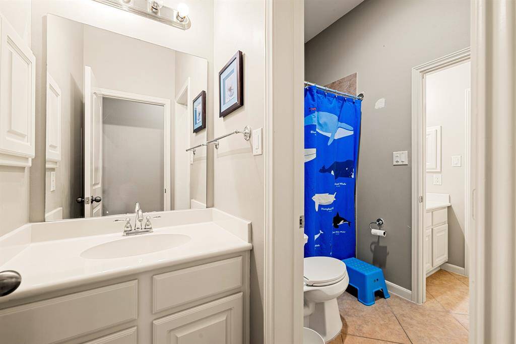 A playful pop of color adds personality to this well-appointed bathroom with plenty of counter space.
