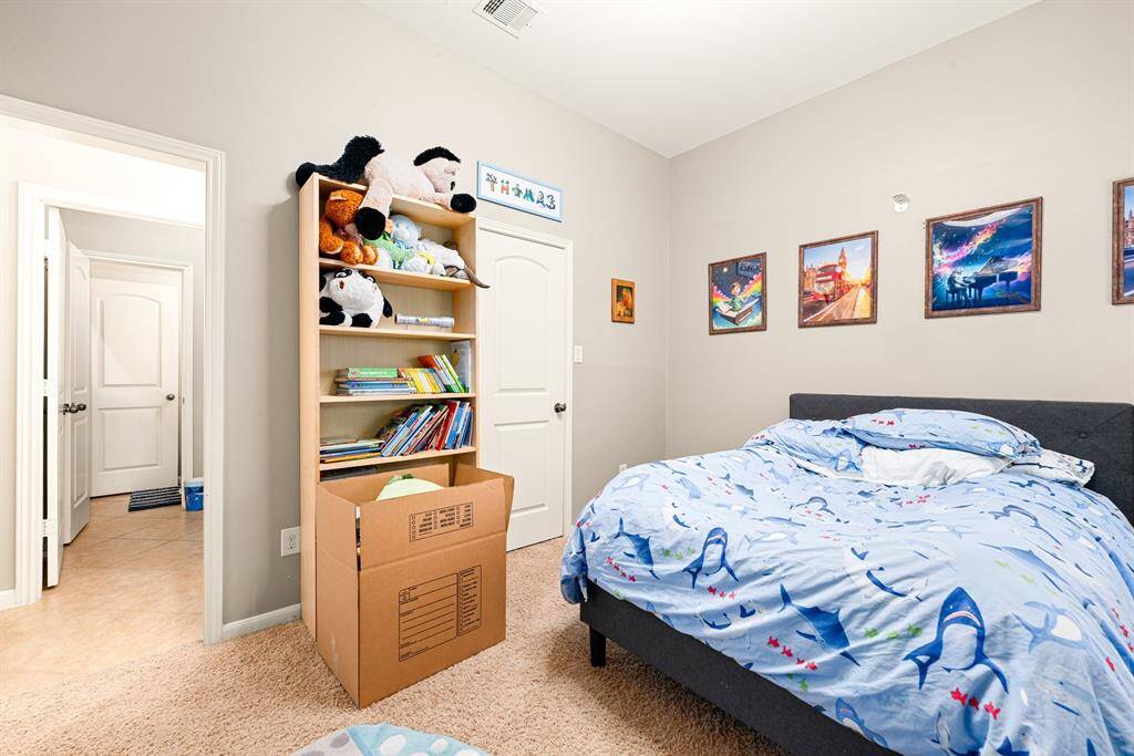 A cozy secondary bedroom offers a functional layout with ample natural light and closet storage.