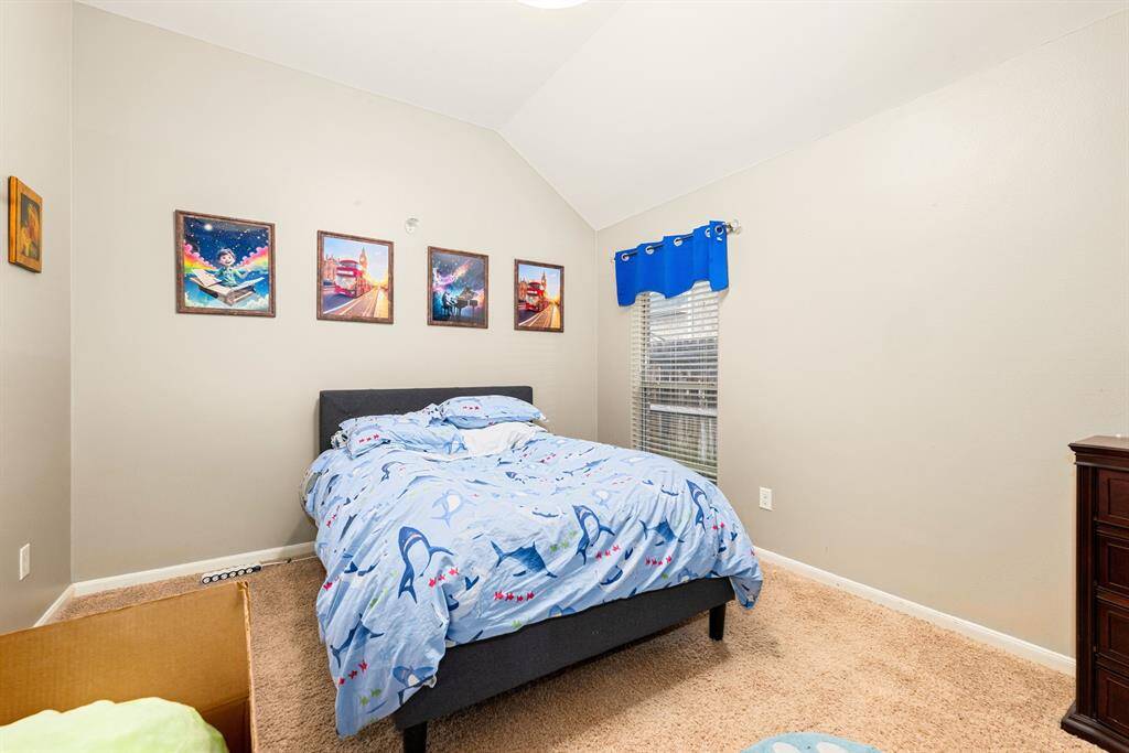 Neutral paint and soft carpet create an inviting feel in this comfortable secondary bedroom.