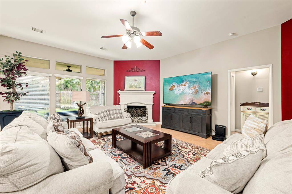 The spacious family room is filled with natural light and features a ceiling fan for year-round comfort.