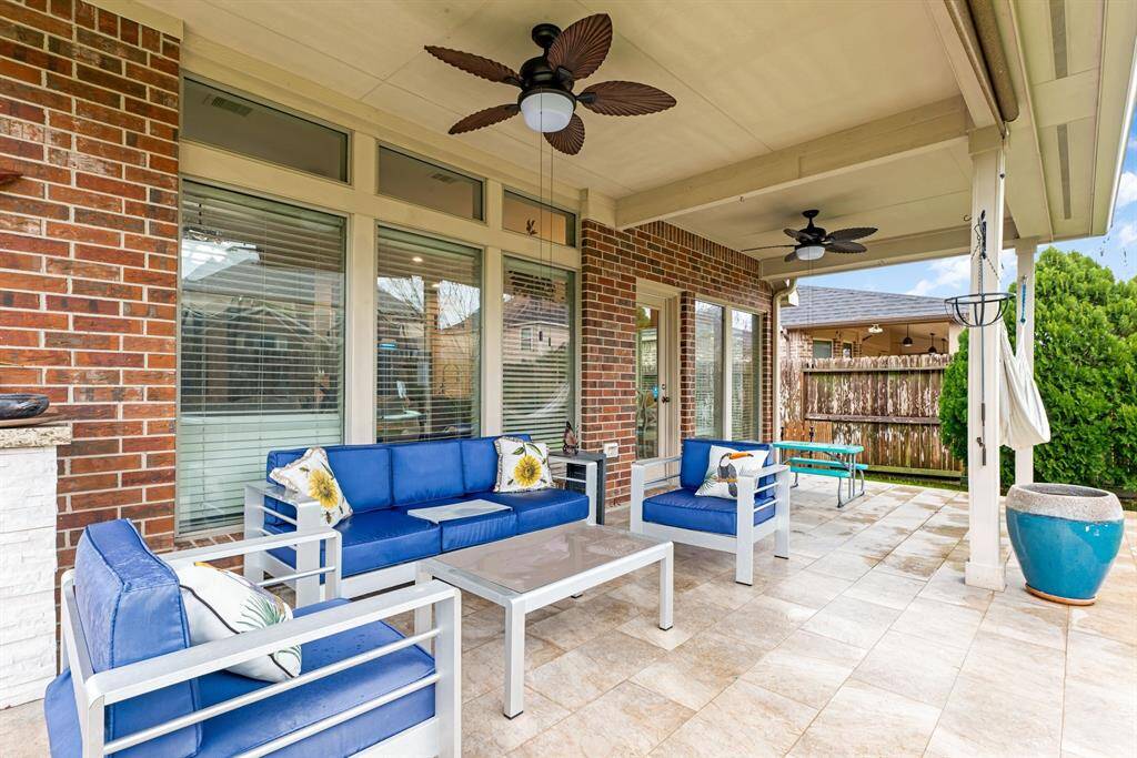 Enjoy outdoor living year-round with this covered patio featuring updated ceiling fans and plenty of seating space.