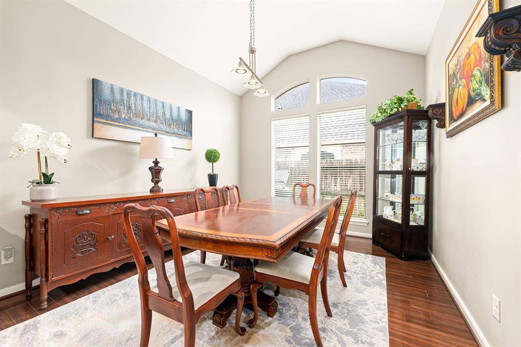 The bright formal dining room offers soaring ceilings, large windows, and a classic layout perfect for gatherings.