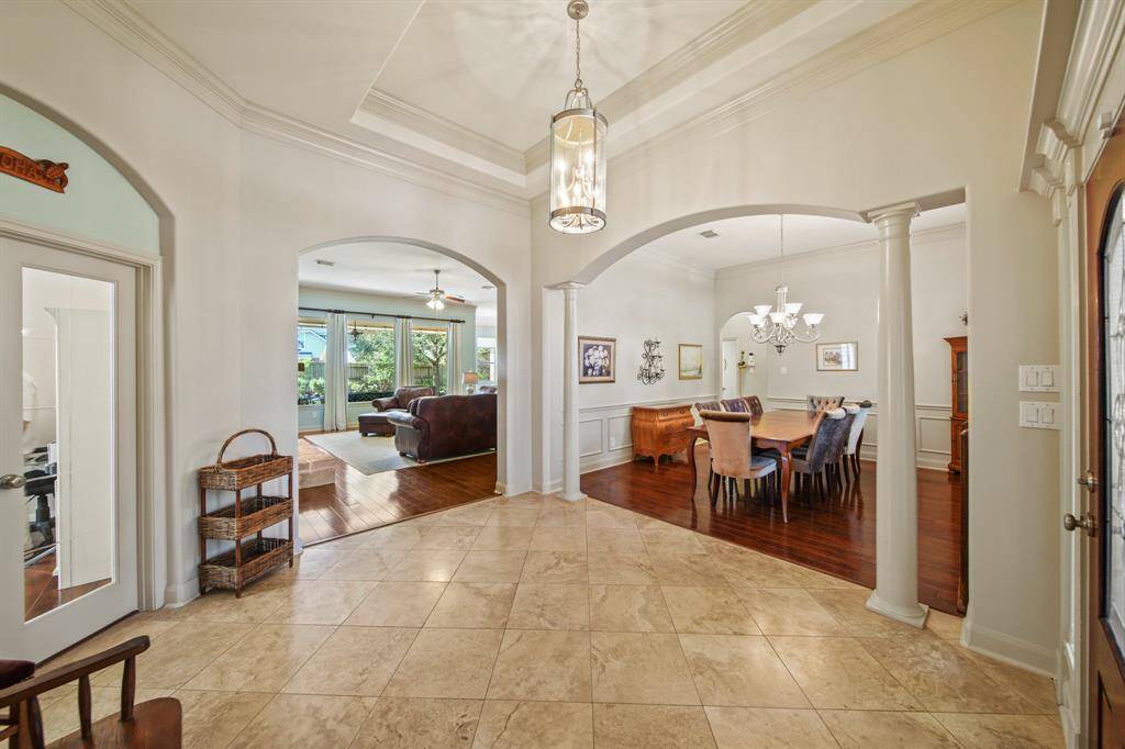 This inviting home features a spacious, elegant entry with tile flooring and high ceilings. It opens into a formal dining area with hardwood floors and a cozy living room with large windows that provide plenty of natural light. Perfect for entertaining and family gatherings.