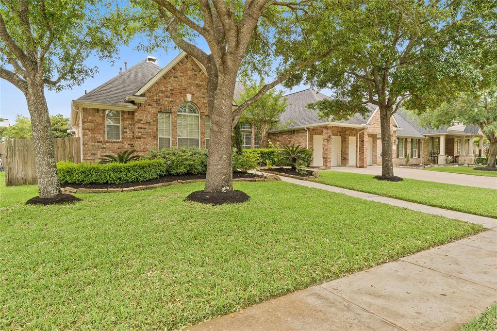 Lush shade trees enhance the curb appeal of this charming home, offering a serene and inviting atmosphere.