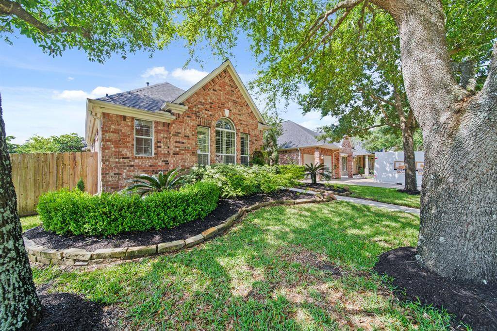 Charming brick home with a well-maintained front yard featuring lush greenery and mature trees. The property offers a spacious driveway and attractive landscaping for great curb appeal.