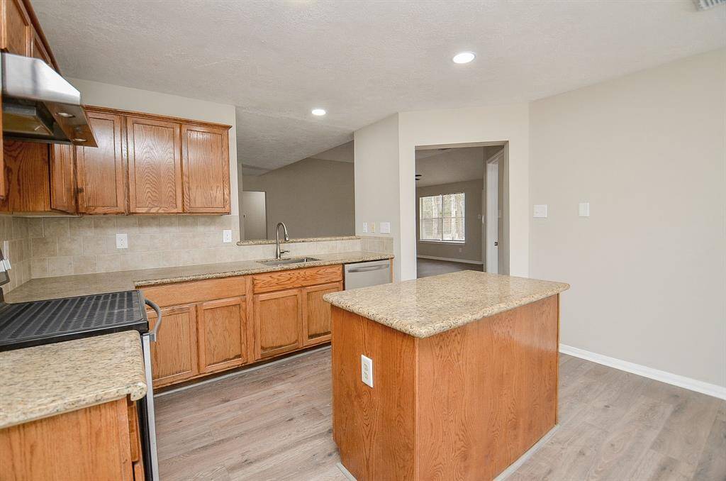 The kitchen offers ample counter and cabinet space, complemented by recessed lighting. Its open layout seamlessly connects to the family and dining rooms, creating a bright and welcoming atmosphere.