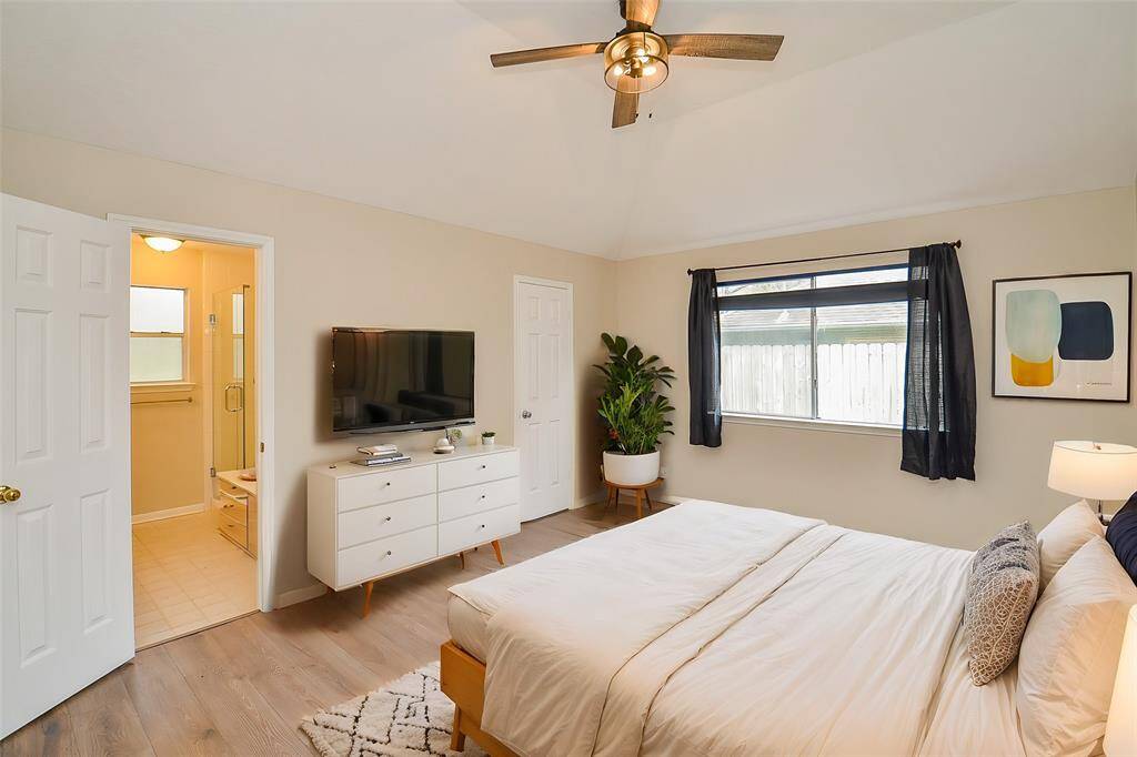 Just off the living room is the primary suite, featuring double windows that offer views of the side yard. The room boasts raised ceilings and includes a spacious walk-in closet.