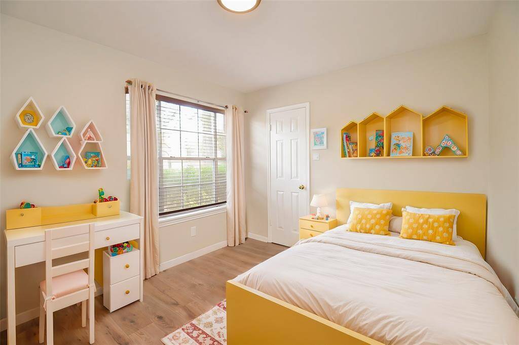 This front bedroom has a large window looking out toward the front yard. The door pictured here opens to a walk-in closet.
