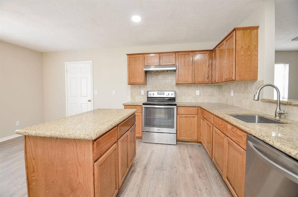 The kitchen features a spacious breakfast area with double windows that let in plenty of natural light. A door toward the back leads to a large utility room and a massive pantry for added convenience.