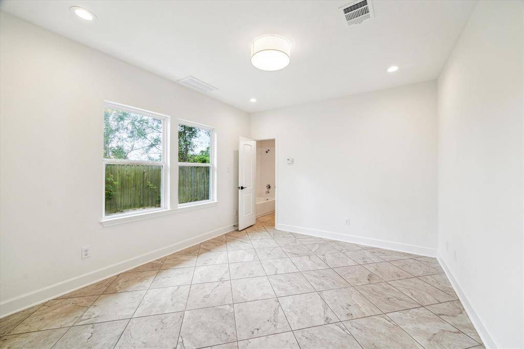 The ground-floor secondary bedroom has a tile floor and its own ensuite bath.