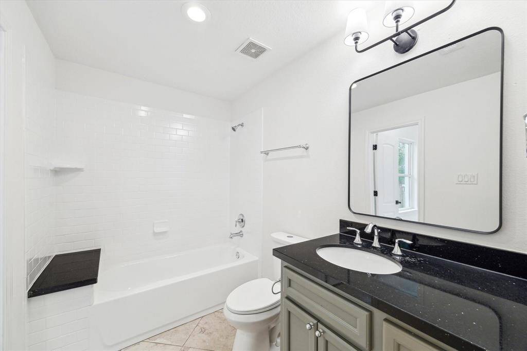 This secondary bedroom features quartz tops and a classy, modern vanity.