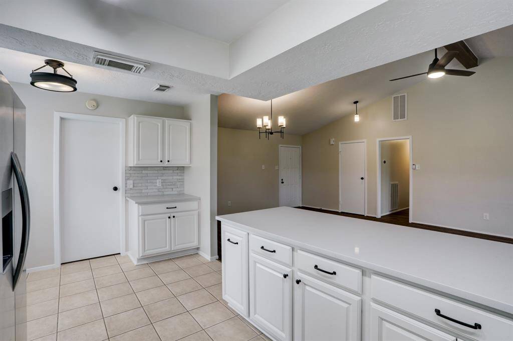 A view from the other direction shows a hidden cabinet in the breakfast area, as well as a look toward the in-home laundry room and pantry.