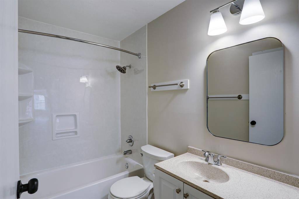 The secondary bathroom is at the end of the bedroom hallway.  In addition to the upgrades, a large linen closet is behind the door.