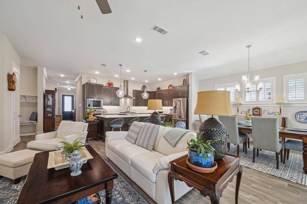 This view highlights the seamless flow of the living, dining, and kitchen area, looking toward the elegant front entrance. The open-concept design, filled with natural light, creates a welcoming and functional space for entertaining and daily living.