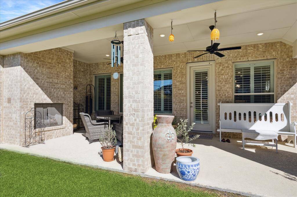 The spacious covered patio includes an outdoor gaslog fireplace, two ceiling fans, and ample room for outdoor seating, making it perfect for entertaining guests or relaxing in comfort.