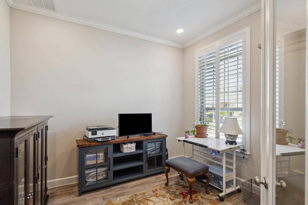 The private home office boasts double glass doors, plantation shutters, and abundant natural light, making it the perfect space for work or study.