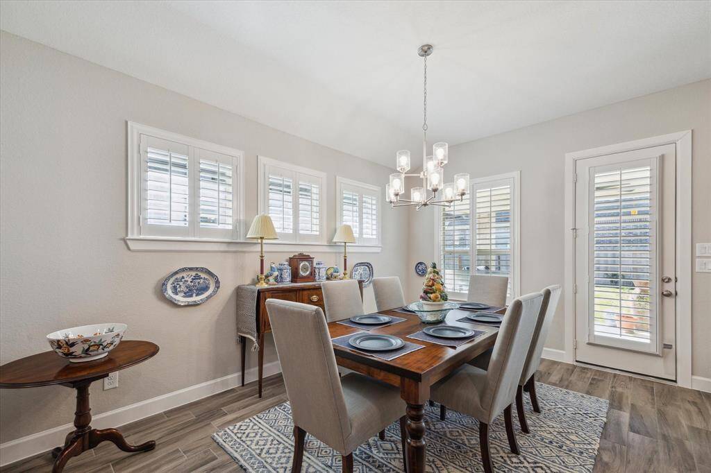 The formal dining area is bright and inviting, with plantation shutters and plenty of space for hosting gatherings with family and friends.