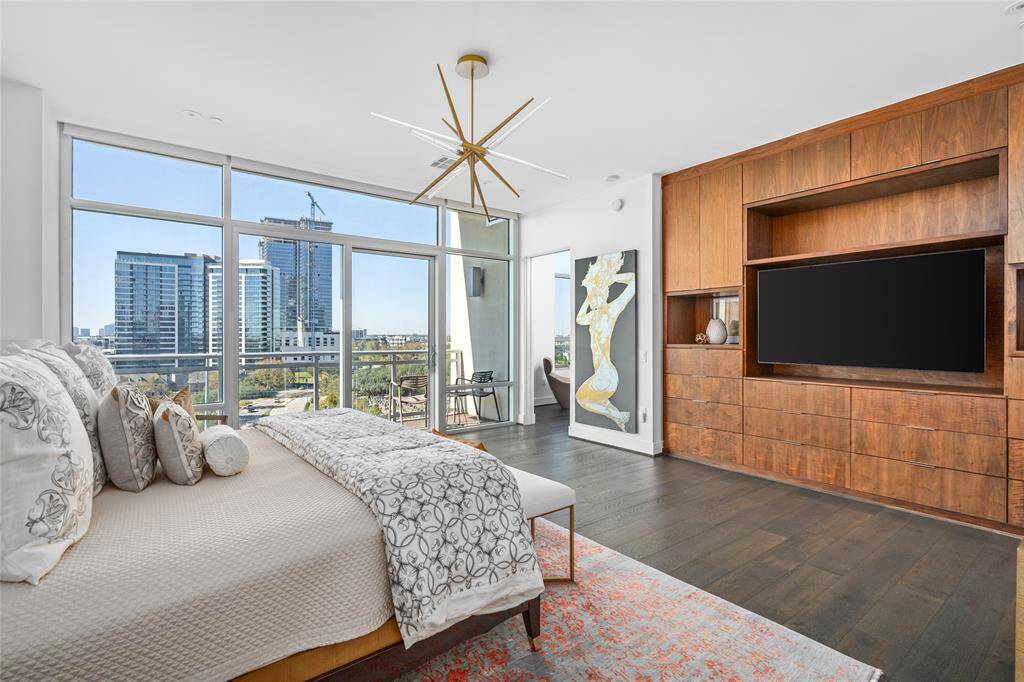 Floor-to-ceiling windows and a private balcony provide the primary bedroom with stunning west, north, and south views. The space is further enhanced with auto-blinds and ample custom built-in storage, creating a perfect blend of luxury and functionality.