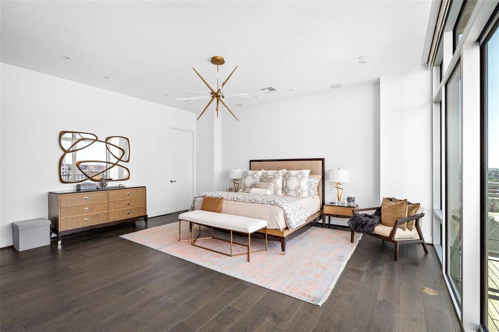 The primary bedroom features sleek hardwood floors and integrated Savant surround sound, offering a serene and modern retreat with thoughtful details for ultimate comfort.