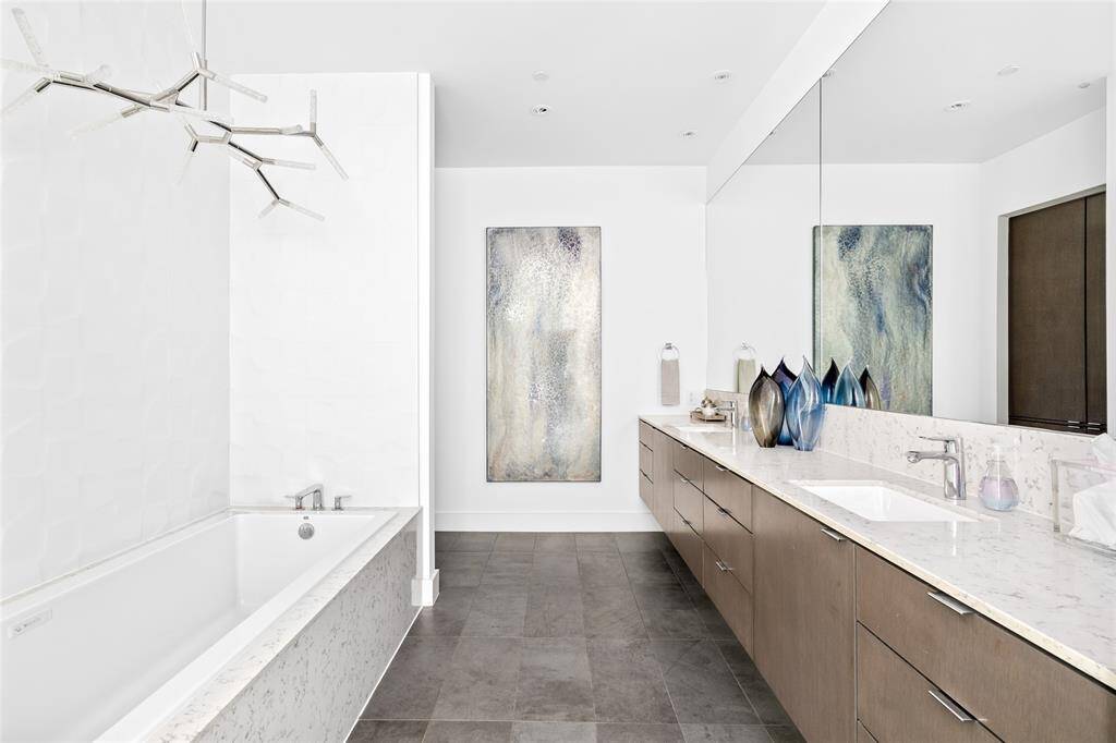 Luxury is found in every detail in this primary bathroom designed by Eggersmann Kitchen & Home. Featuring sleek Silestone counters, handsome Hansgrohe plumbing fixtures, a magnificent MTI Whirlpool Air bathtub, and a gorgeous glass-enclosed walk-in shower, the primary bath is a serene and sophisticated sanctuary.