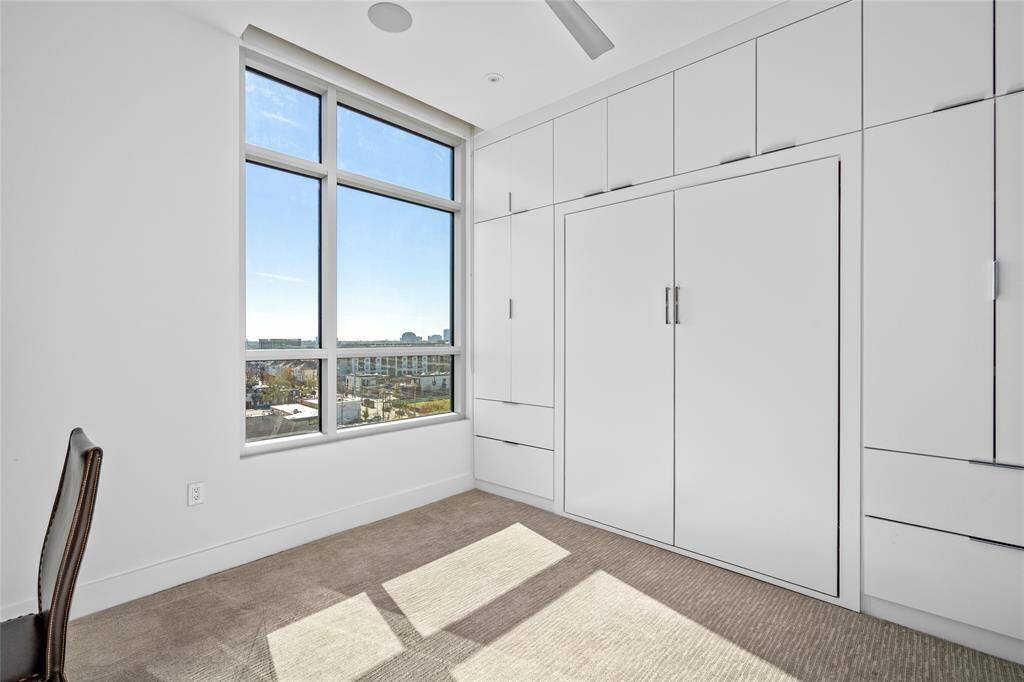 Featuring a built-in Murphy bed, ample storage, window coverings, and integrated Savant surround sound, this secondary bedroom combines functionality with modern conveniences.