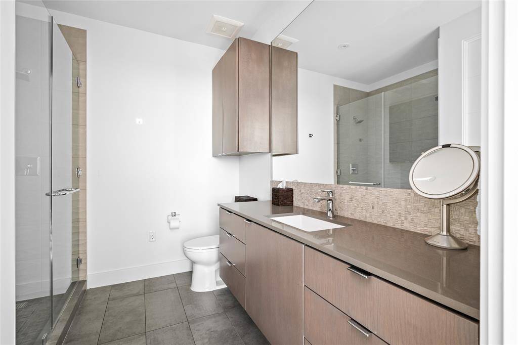 The third ensuite bathroom is a refined sanctuary of style and comfort, featuring sleek Silestone counters that exude modern elegance and a spacious glass-enclosed walk-in shower that offers a spa-like retreat. Thoughtfully designed for privacy and luxury, each bedroom in the residence is paired with its own ensuite bath, ensuring unparalleled convenience and sophistication.