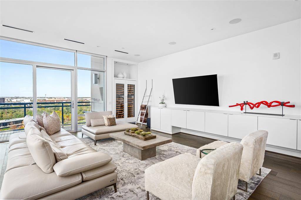 Combining function and elegance, the modern living space features custom built-ins and ample storage for a seamless and organized look. The 100+ bottle Sub-Zero wine fridge is perfect for entertaining and showcasing your collection while floor-to-ceiling windows allow natural light to pour in and create a bright and inviting atmosphere with stunning views.