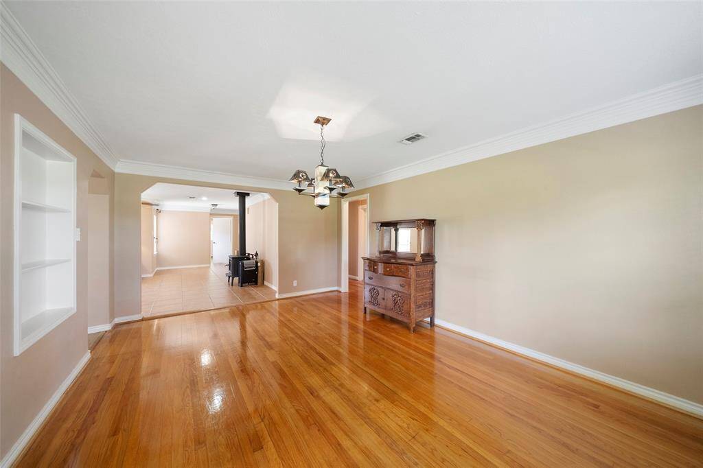 Beautiful hardwood floors, crown molding, and built-in shelving highlight this flexible space ready for your personal touch.