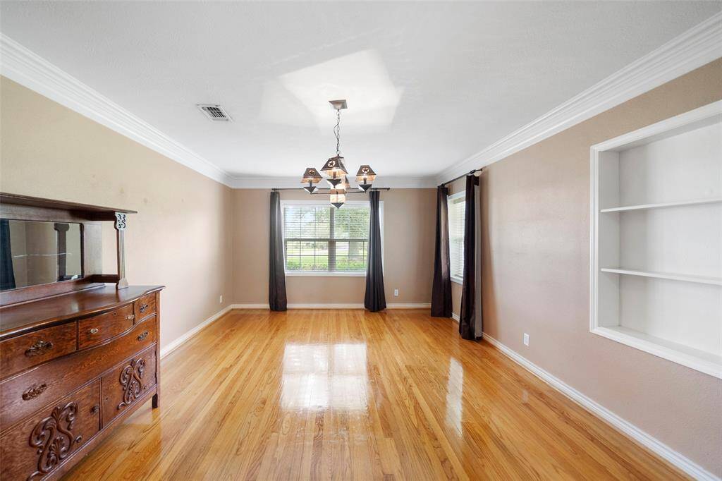 Natural light pours into this versatile front room, perfect for formal dining, a sitting area, or even a home office setup.
