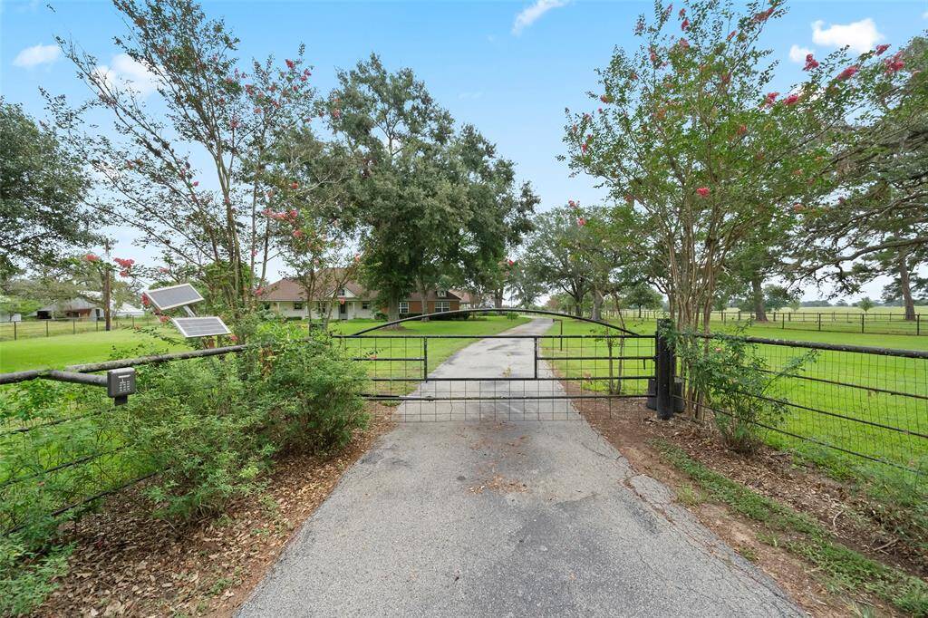 Secure gated entry with solar panel access welcomes you home—enjoy peace of mind and a picturesque tree-lined drive leading to the residence.