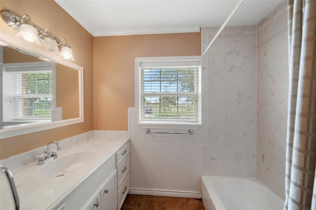 Classic charm with beadboard detail, large vanity, and a clean tub/shower combo—convenient to additional bedrooms.