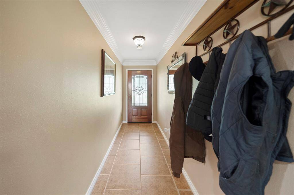 A welcoming entryway with crown molding and tile flooring sets the tone for this well-cared-for home — ready for boots, jackets, and everyday ease.