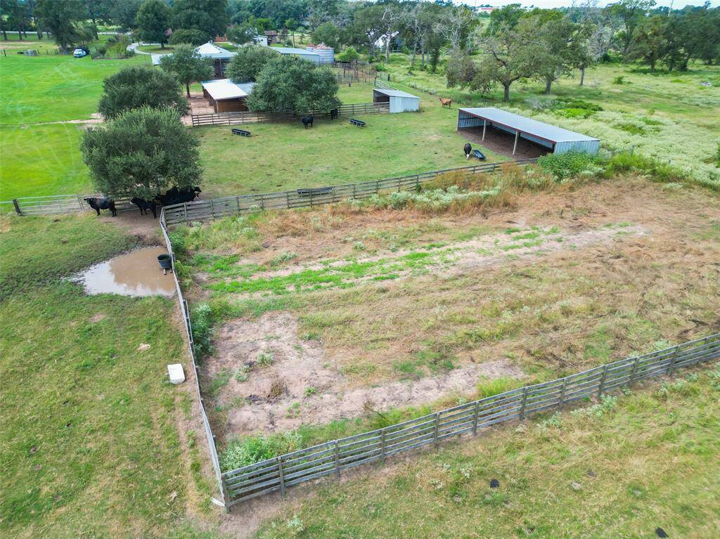 Scenic aerial view of the barnyard, paddocks, and surrounding pasture. Tenants may enjoy personal use of the onsite riding arena—non-commercial use only. Events, lessons, or group rides involving outside participants are not permitted. Basic arena upkeep, safety, and care are tenant responsibilities per lease.